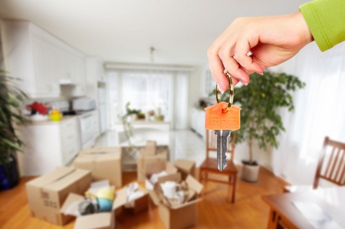 Professional movers protecting walls and furniture during a flat relocation
