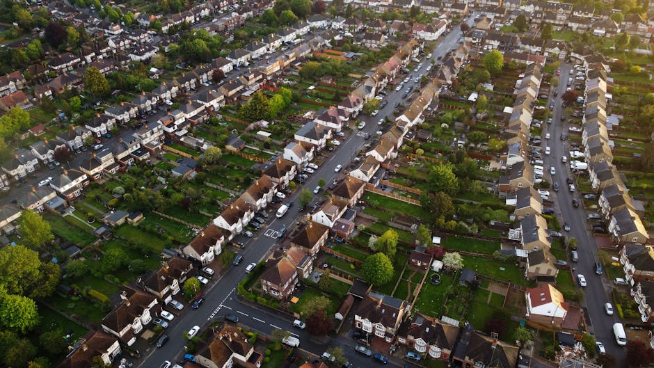 An aerial view of a residential neighbourhood in Edgware showing densely packed houses with pitched roofs, tree-lined streets, and parked cars on the roads and driveways. The image captures a typical 